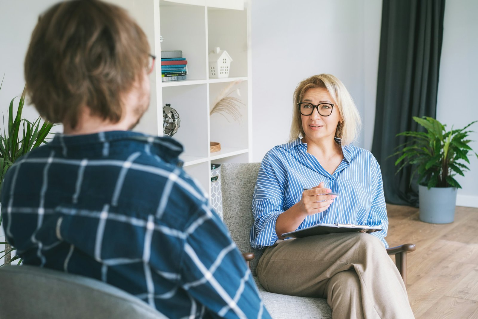 Professional psychotherapy. Female psychologist having session with male patient at mental clinic,